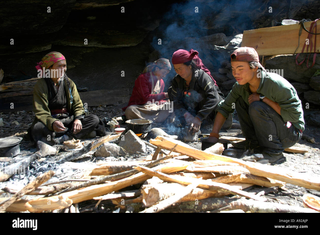 Nepali family at lunch at their fire pit near Chame NarPhu Annapurna