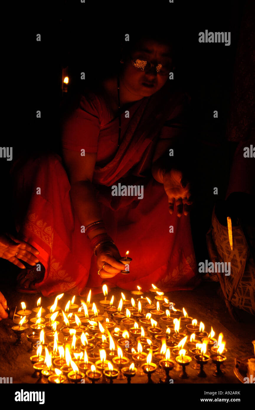 Woman is illuminated by burning butter lamps from the floor Kathmandu