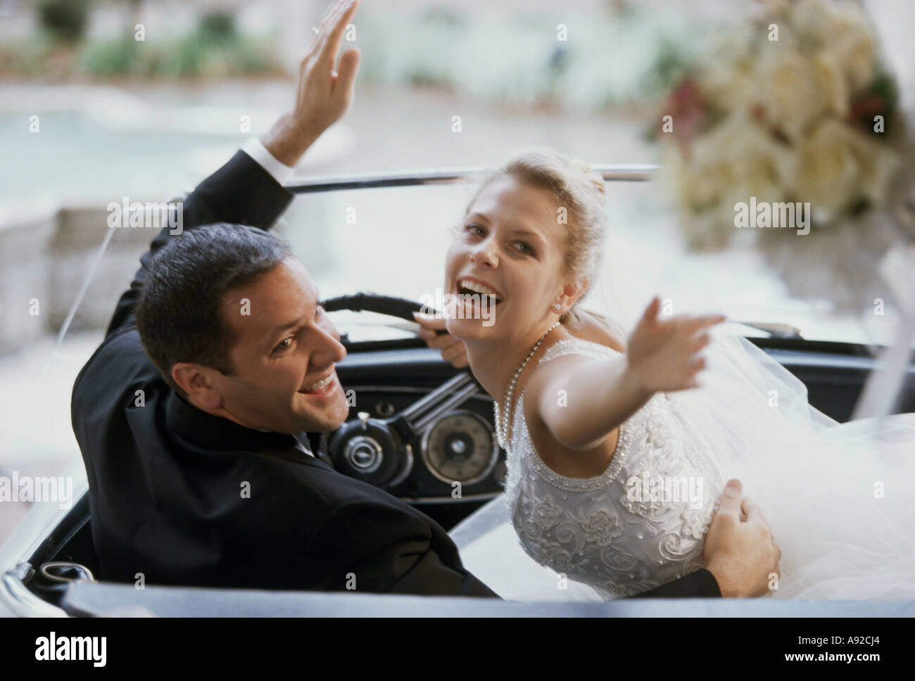 Newlywed couple sitting in a convertible car Stock Photo - Alamy
