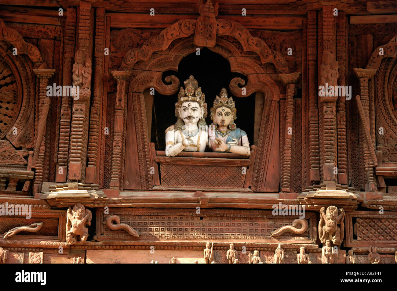 Two wooden figures of god Shiva and Parvati are looking out of a window onto Durbar Square Kathmandu Nepal Stock Photo