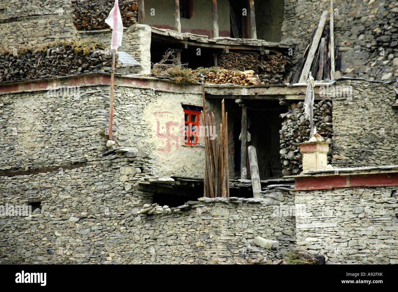 Symbol swastika drewn with red colour at a wall of a house Phu Nar-Phu Annapurna Region Nepal Stock Photo