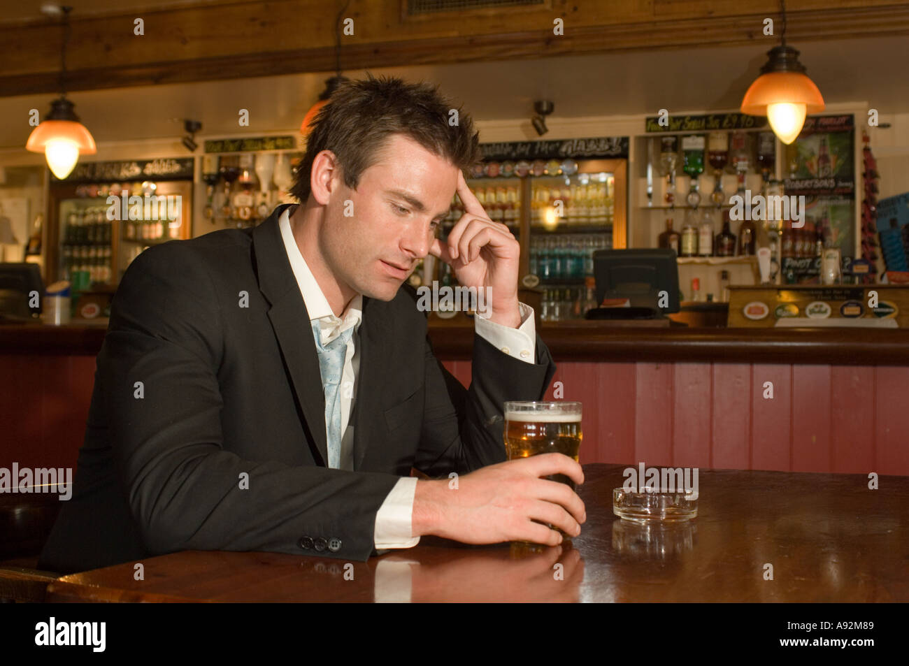 man having a pint in a pub looking thoughtful Stock Photo