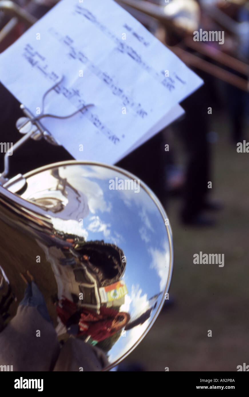 a music stand attached to the end of a trombone with blue sky reflected in the bell Stock Photo