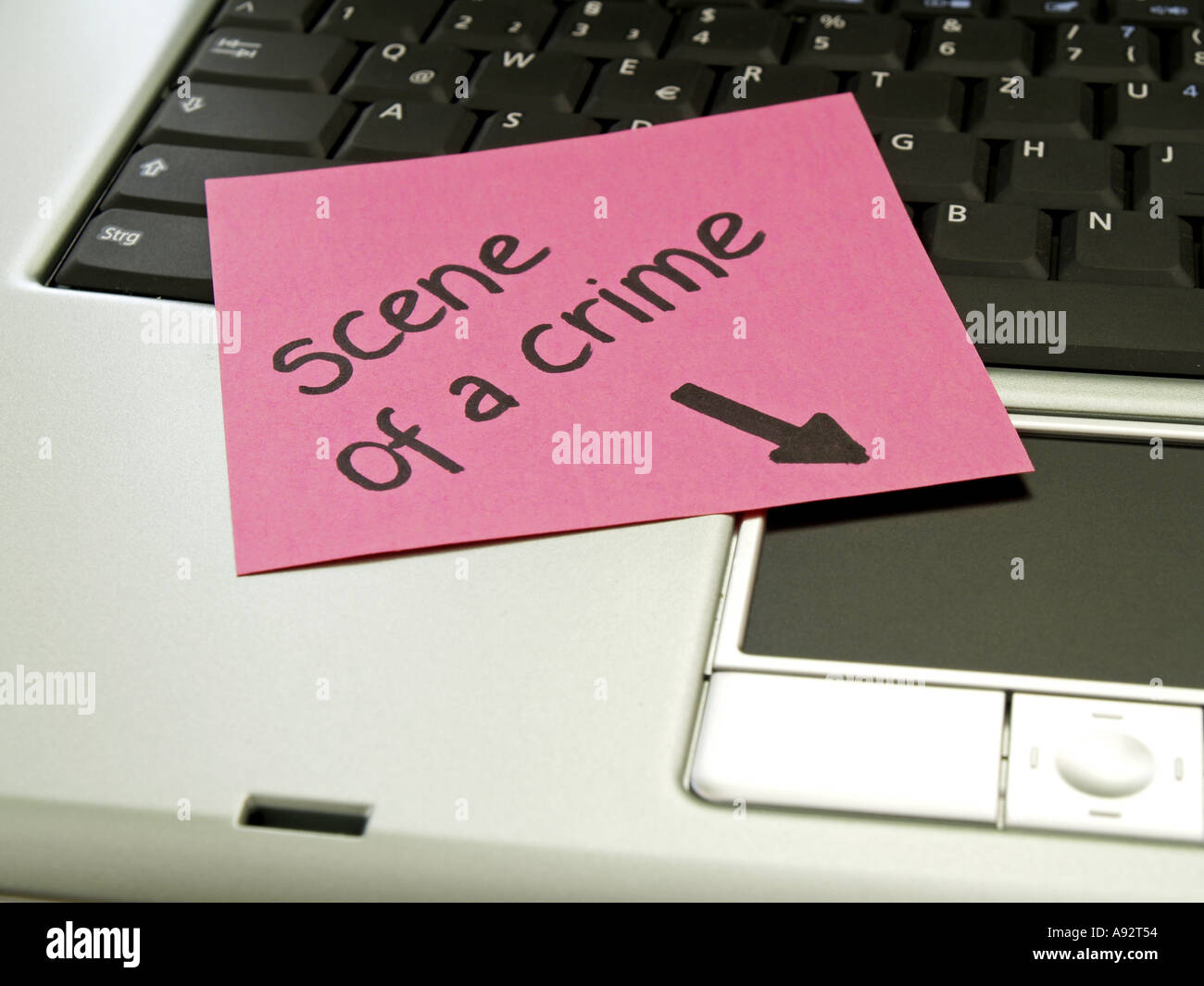 memo note on notebook scene of a crime arrow pointing towards touch pad Stock Photo