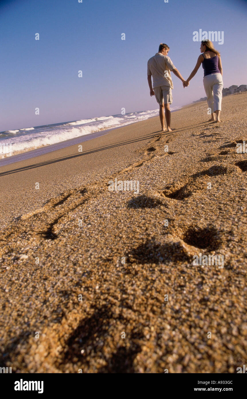 Rear view of a young couple walking together on the beach Stock Photo ...
