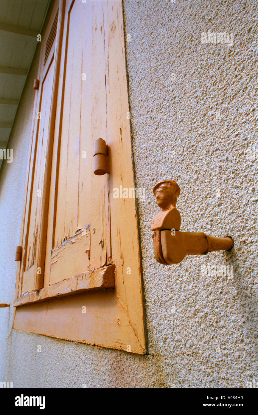 France Bassin d Arcachon Cap Ferret distressed yellow wooden window shutter & cast iron fastener in the form of a bust. JMH0013 Stock Photo