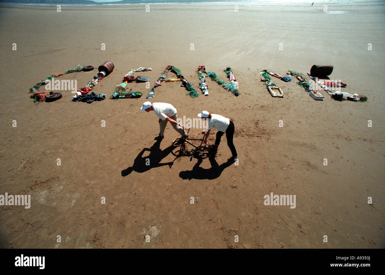Two eco warriors collecting rubbish from a remote Welsh beach make a witty appeal to litterbugs. Stock Photo