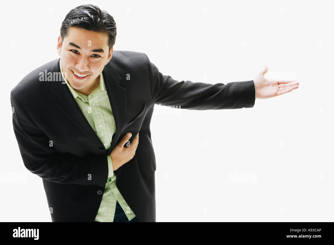 Asian man bowing with arm out Stock Photo