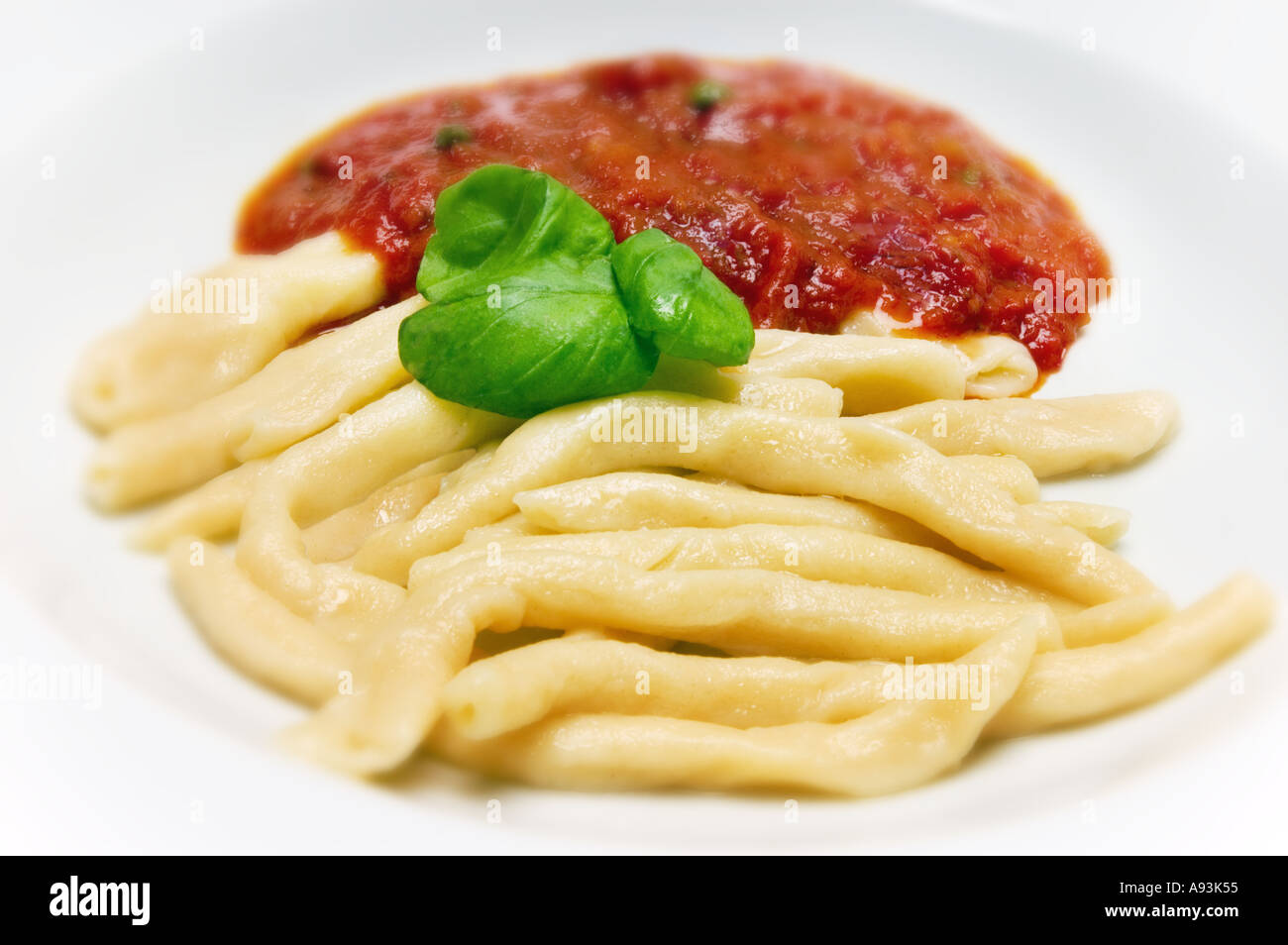 hand made Maccheroni siciliana PASTA speciality special on a white marble plate with tomato sauce gravy  Stock Photo