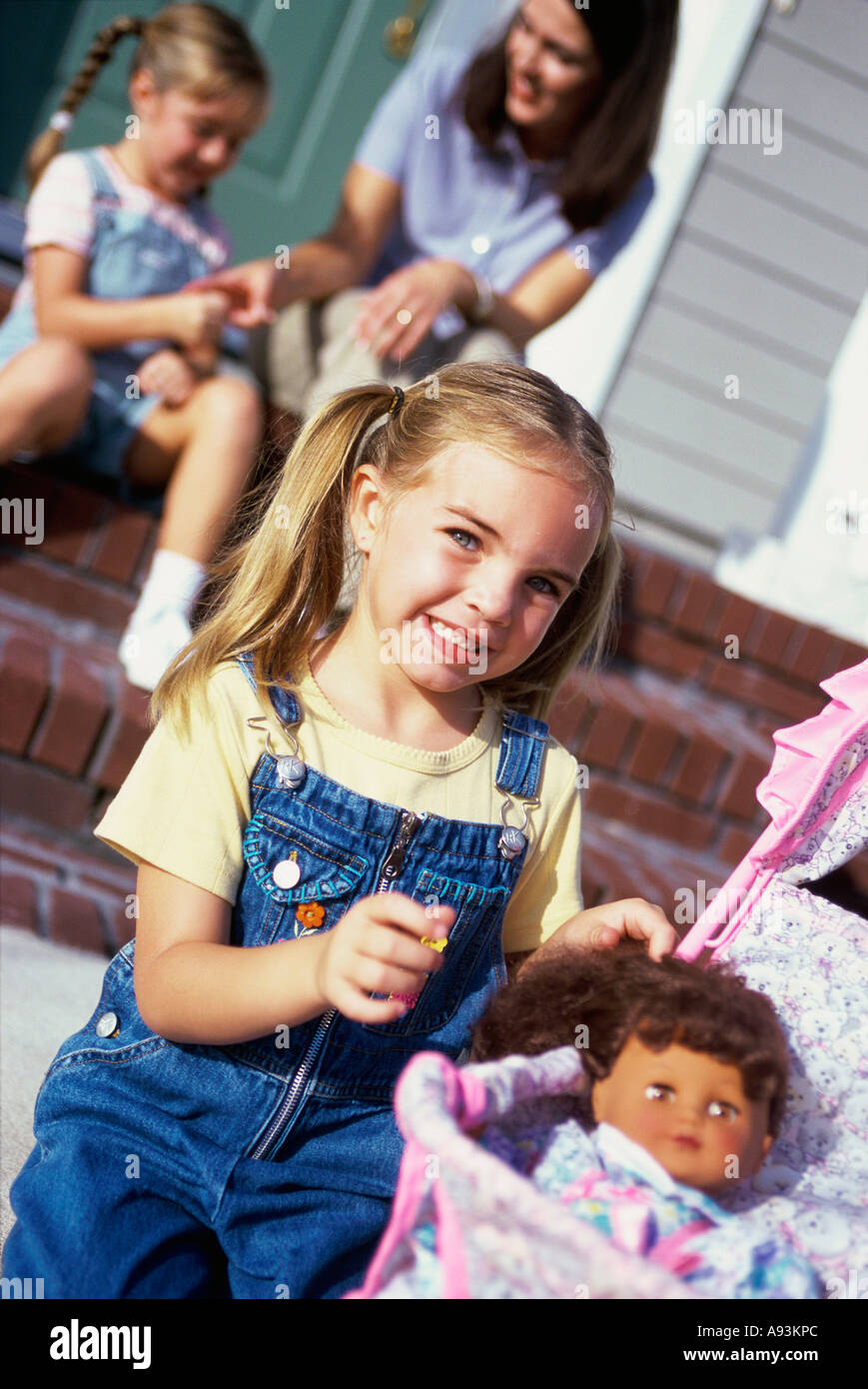 Portrait of a girl playing with a doll Stock Photo - Alamy