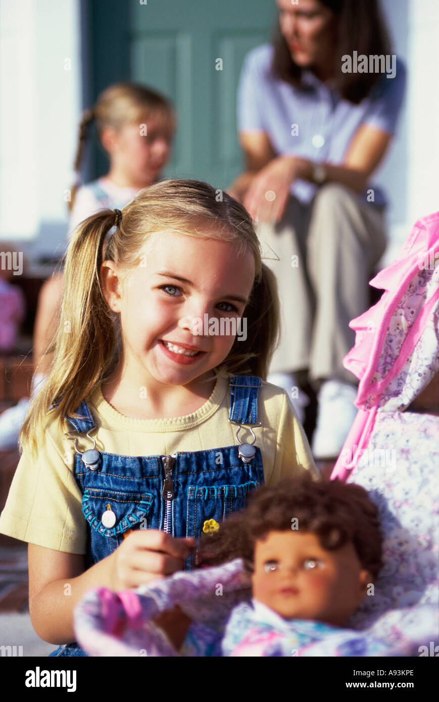 Portrait of a girl playing with a doll Stock Photo - Alamy