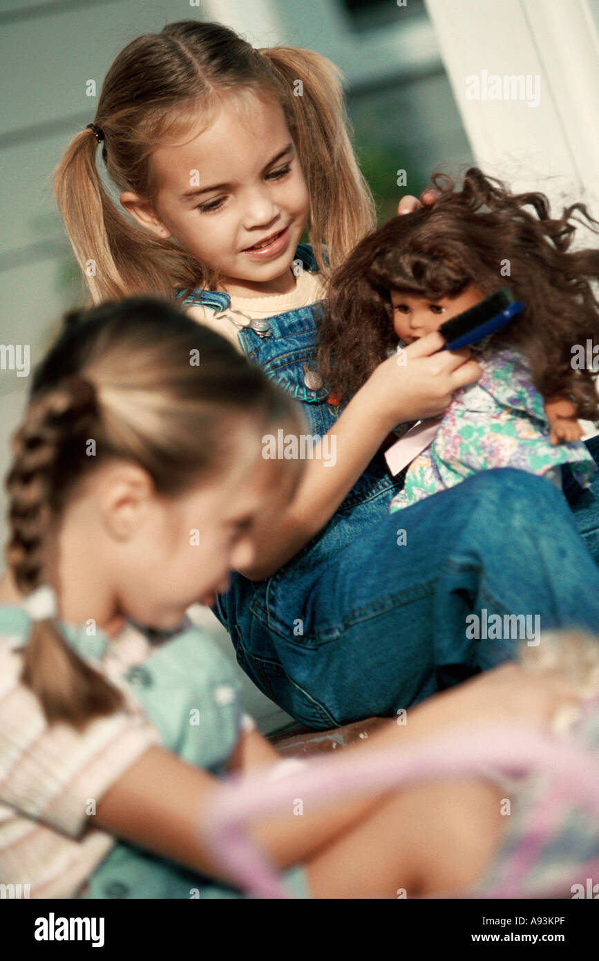 Two girls playing with their dolls Stock Photo