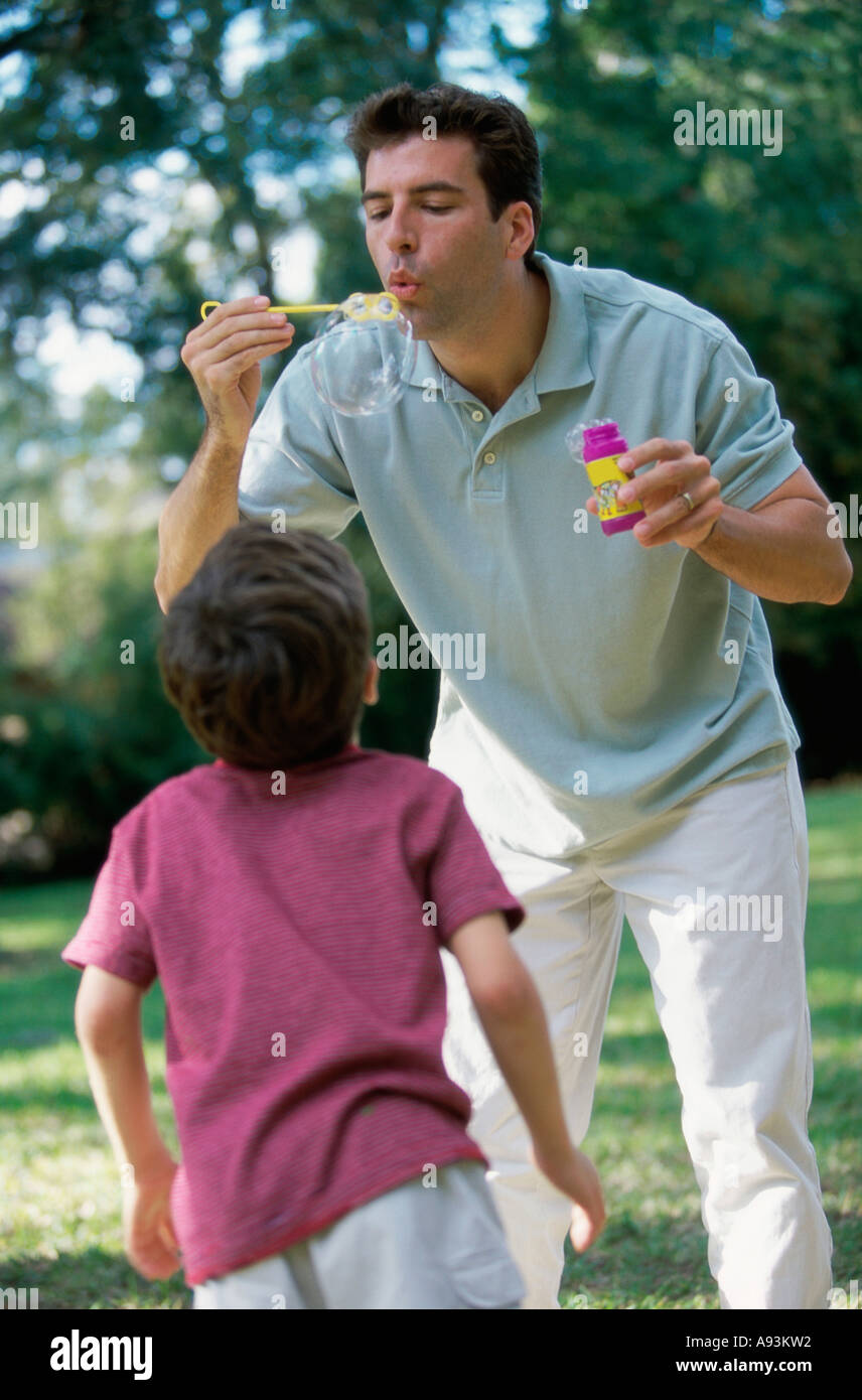 Father blowing bubbles with a bubble wand Stock Photo