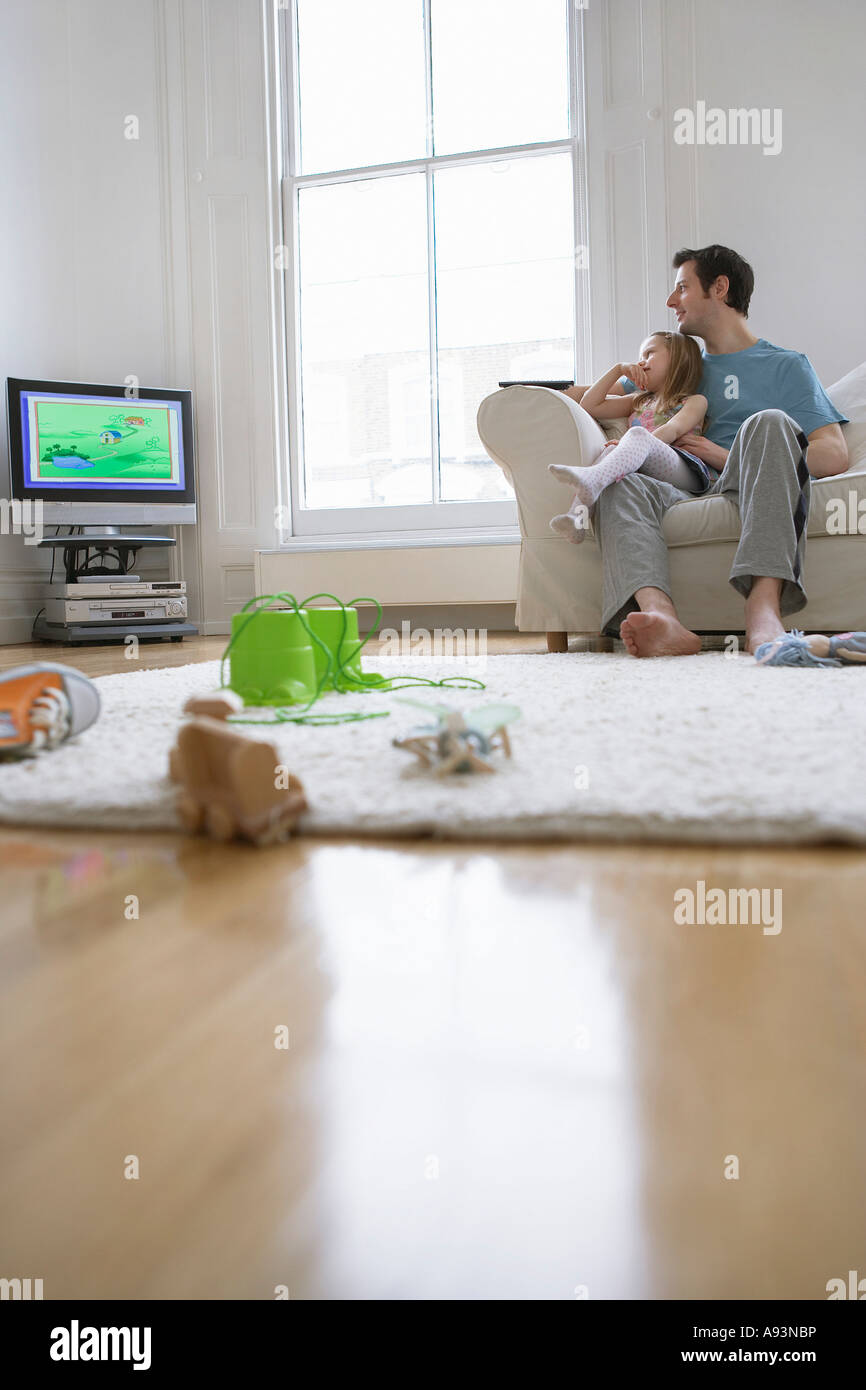 Father and daughter (5-6) watching match in television Stock Photo