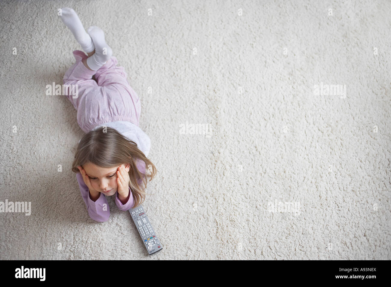Girl (5-6) lying on rug, view from above Stock Photo