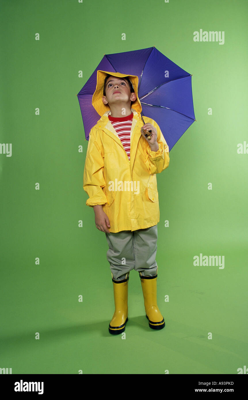 Boy wearing a raincoat and holding an umbrella Stock Photo