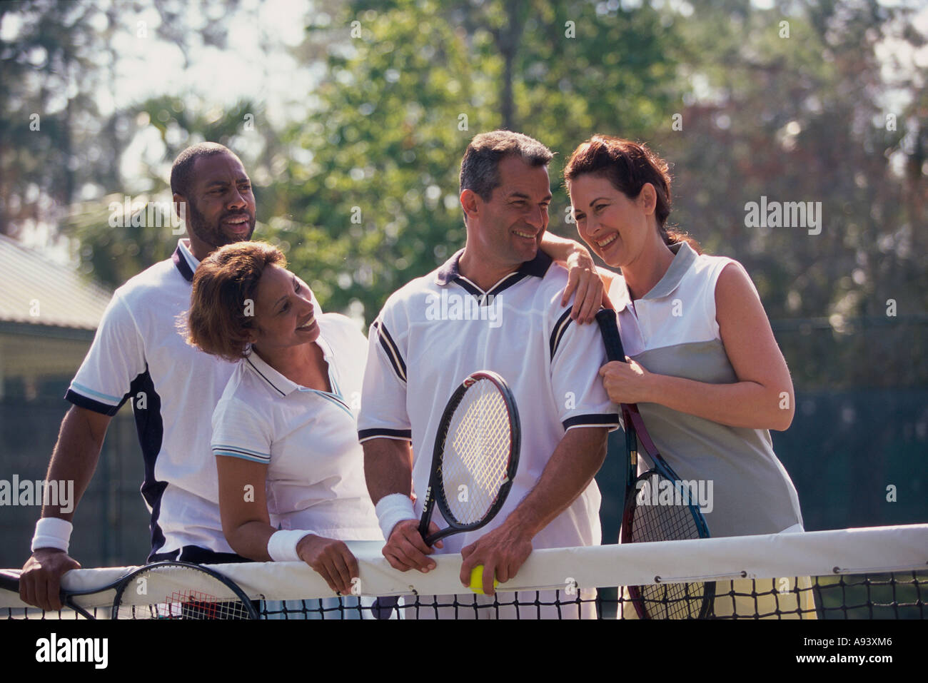 Two mid adult couples playing tennis Stock Photo Alamy