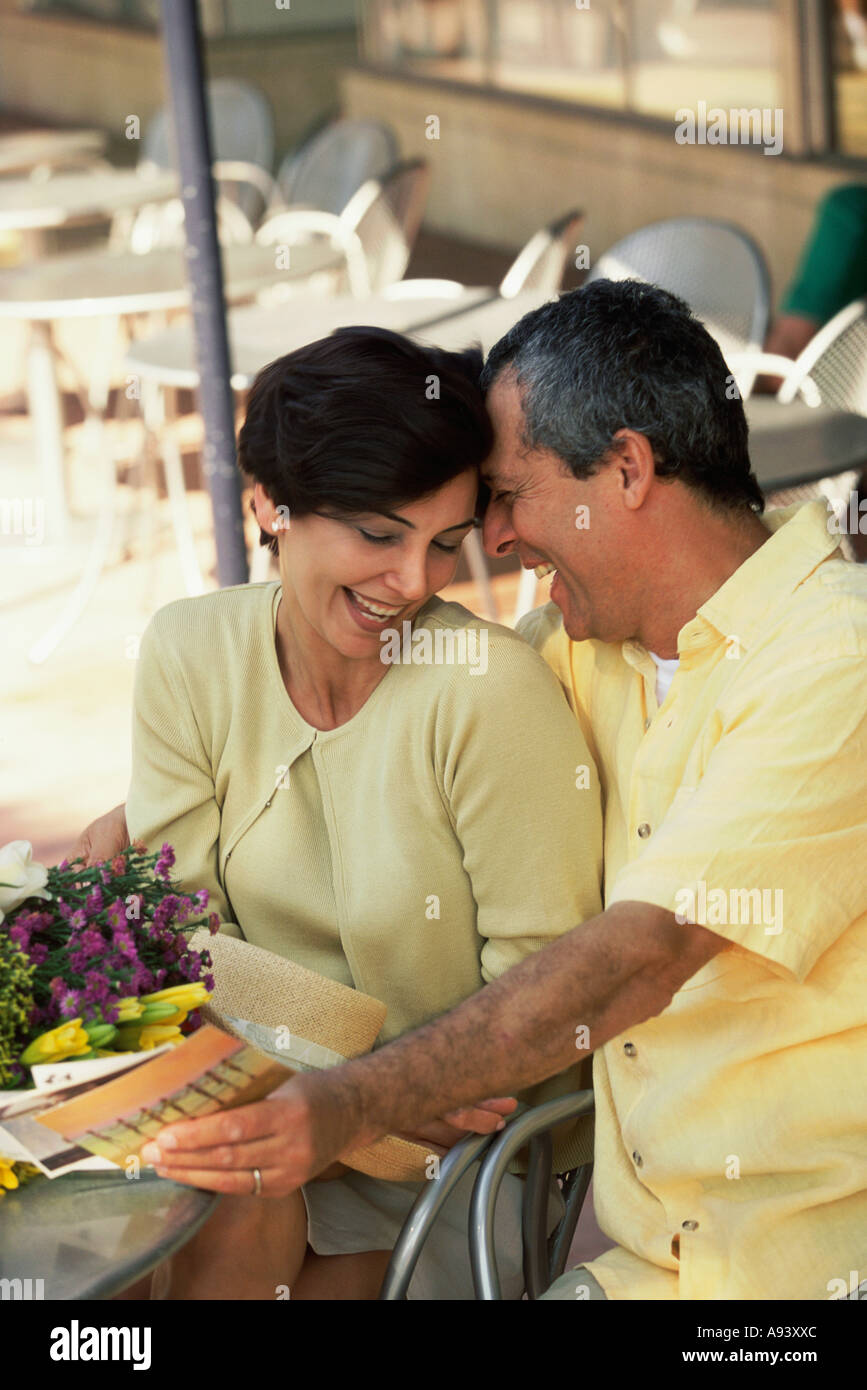Mature man whispering to a mid adult woman Stock Photo