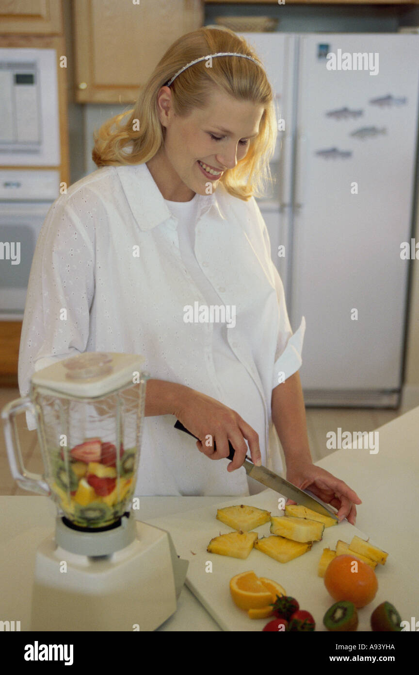 Young pregnant woman cutting fruit Stock Photo Alamy