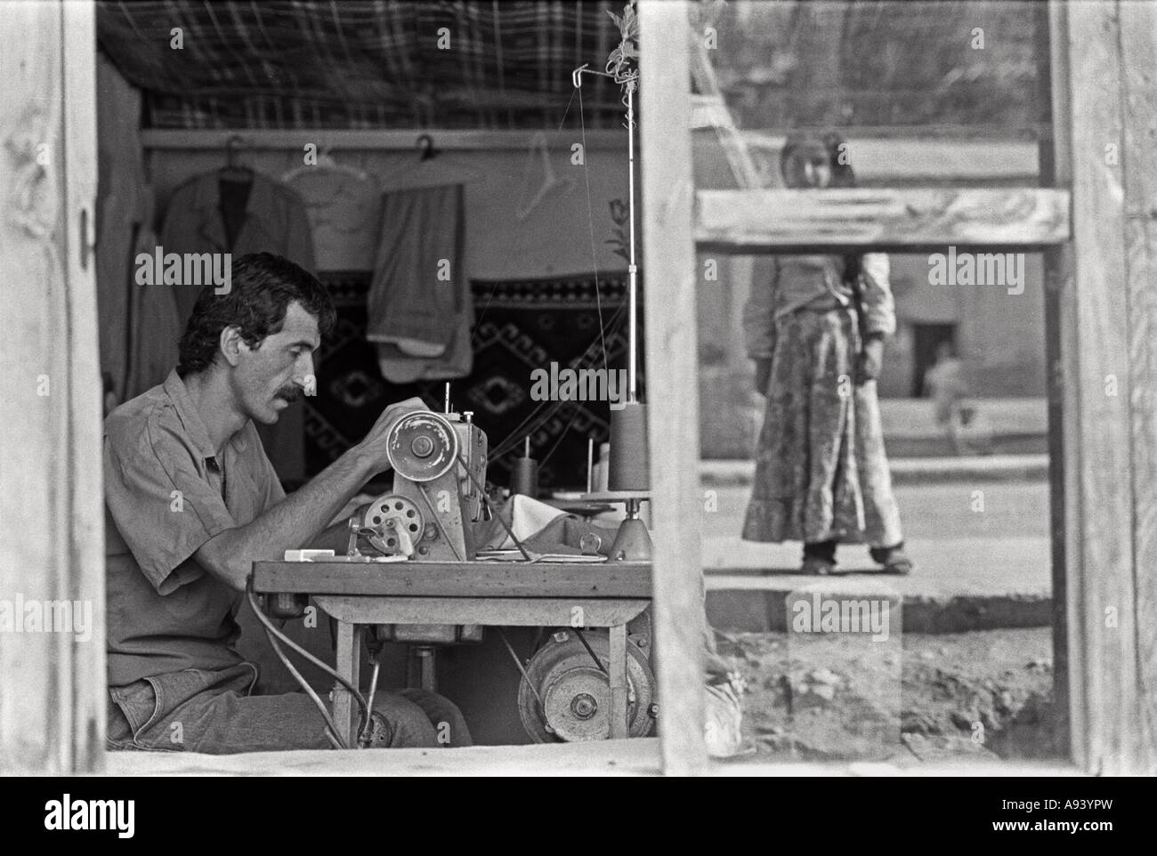 July 1987 Beytussebap south east Turkey Kurdistan A Kurdish girl is reflected in the window of a tailors shop Stock Photo