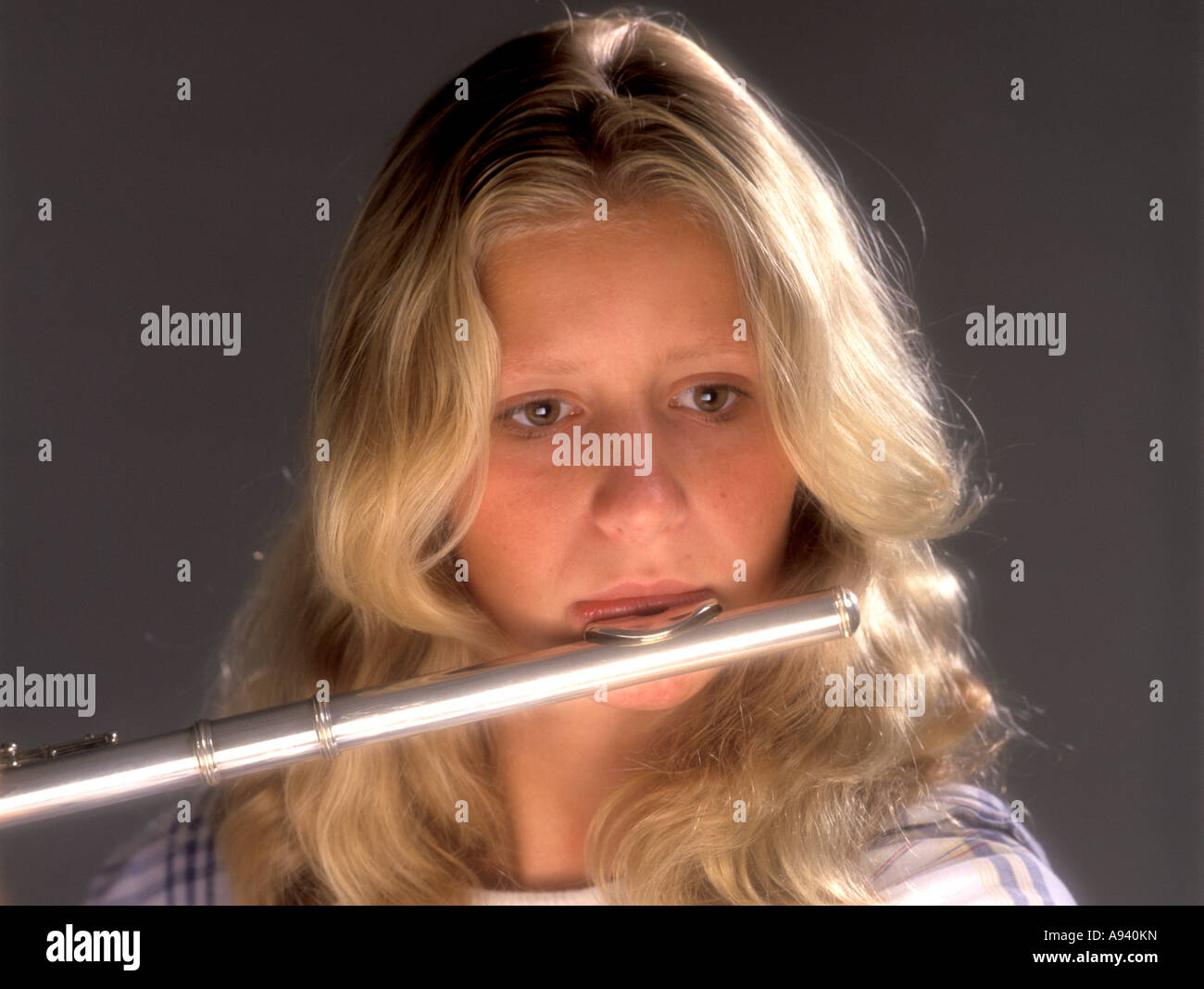Blond girl plays a German flute Stock Photo