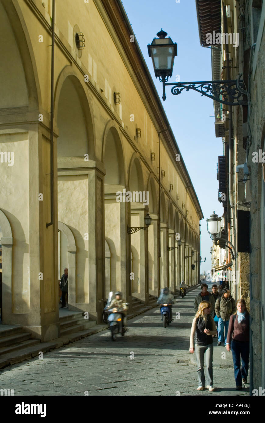 Vertical view of a typical Florentine street [Lungarno delgi Archibusieri] with the arches of the Vasari Corridor on a sunny day Stock Photo