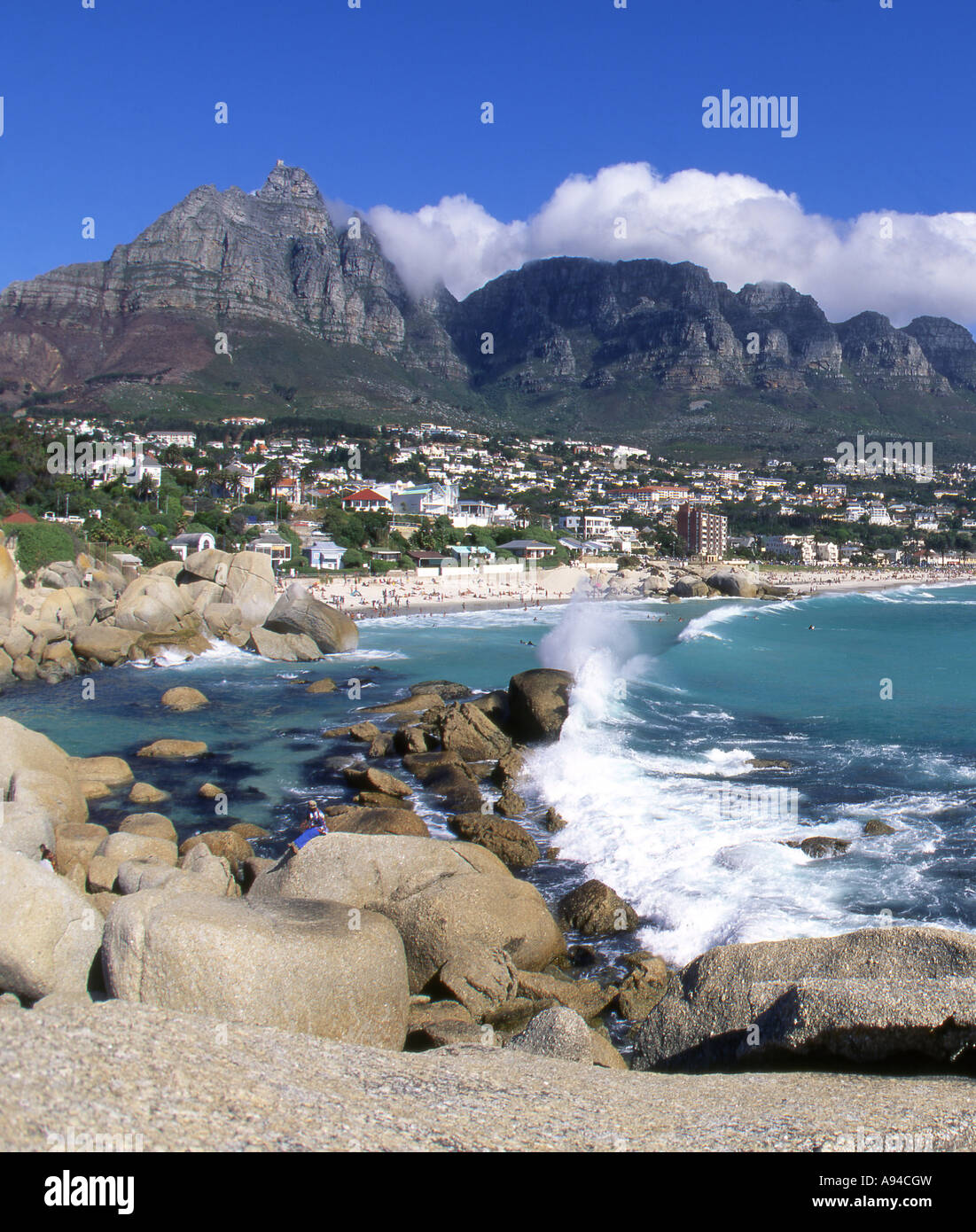 Waves crashing on the rocks at Camps Bay with the twelve apostles in the background Cape Town Western Cape South Africa Stock Photo