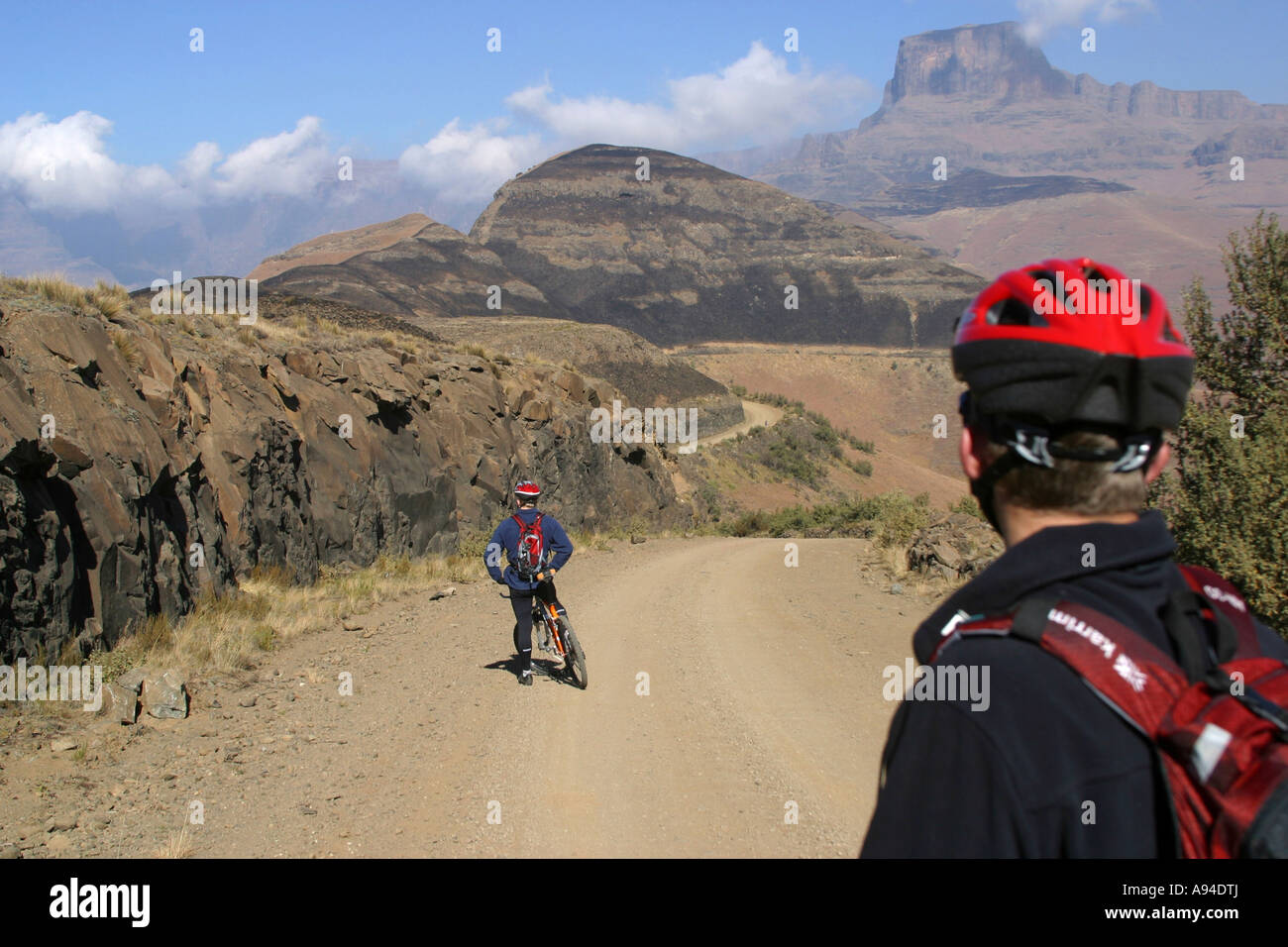 A pair of cyclists mountain biking up to Sentinel Peak Drakensberg Sentinel Kwazulu Natal South Africa Stock Photo