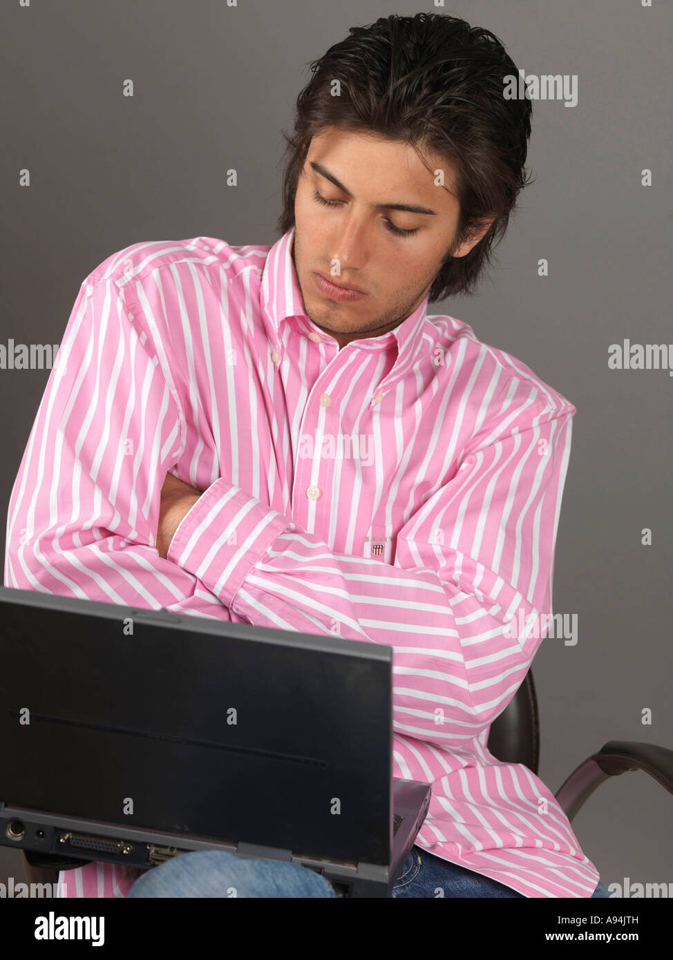 Young Man Working Remotely On A Laptop Computer And A Retro Mobile Cell Phone Closing A Deal Stock Photo