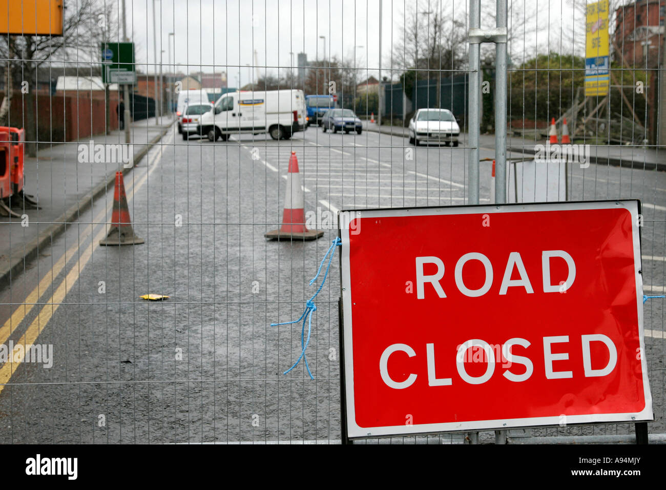 road closed sign fence traffic cones and traffic turning due to road
