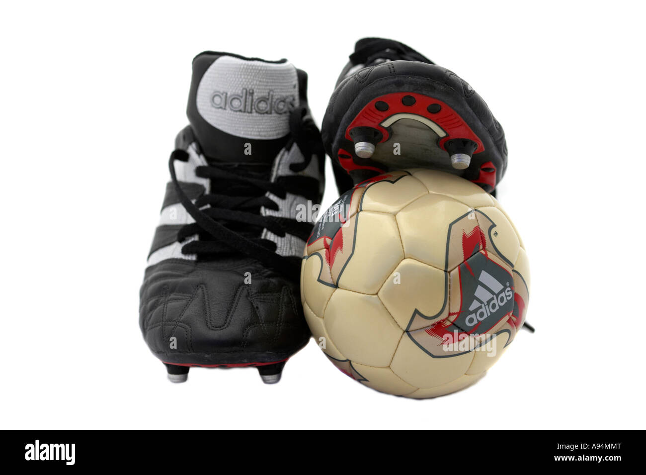 pair of black adidas football boots and mini training football against a white background Stock Photo