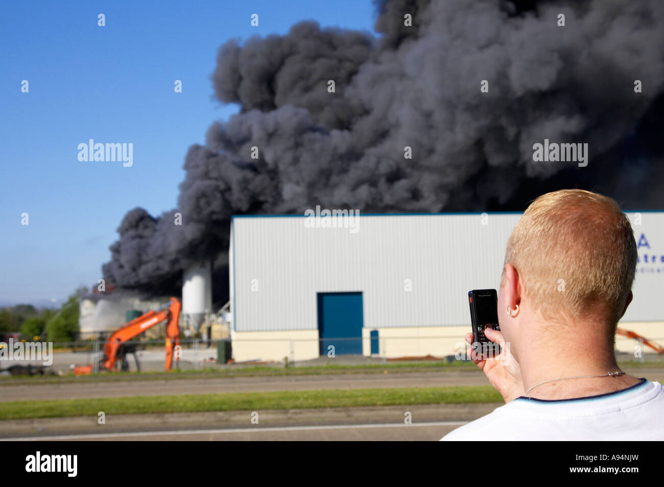 man taking photograph of fire at medical warehouse coleraine using mobile phone camera Stock Photo