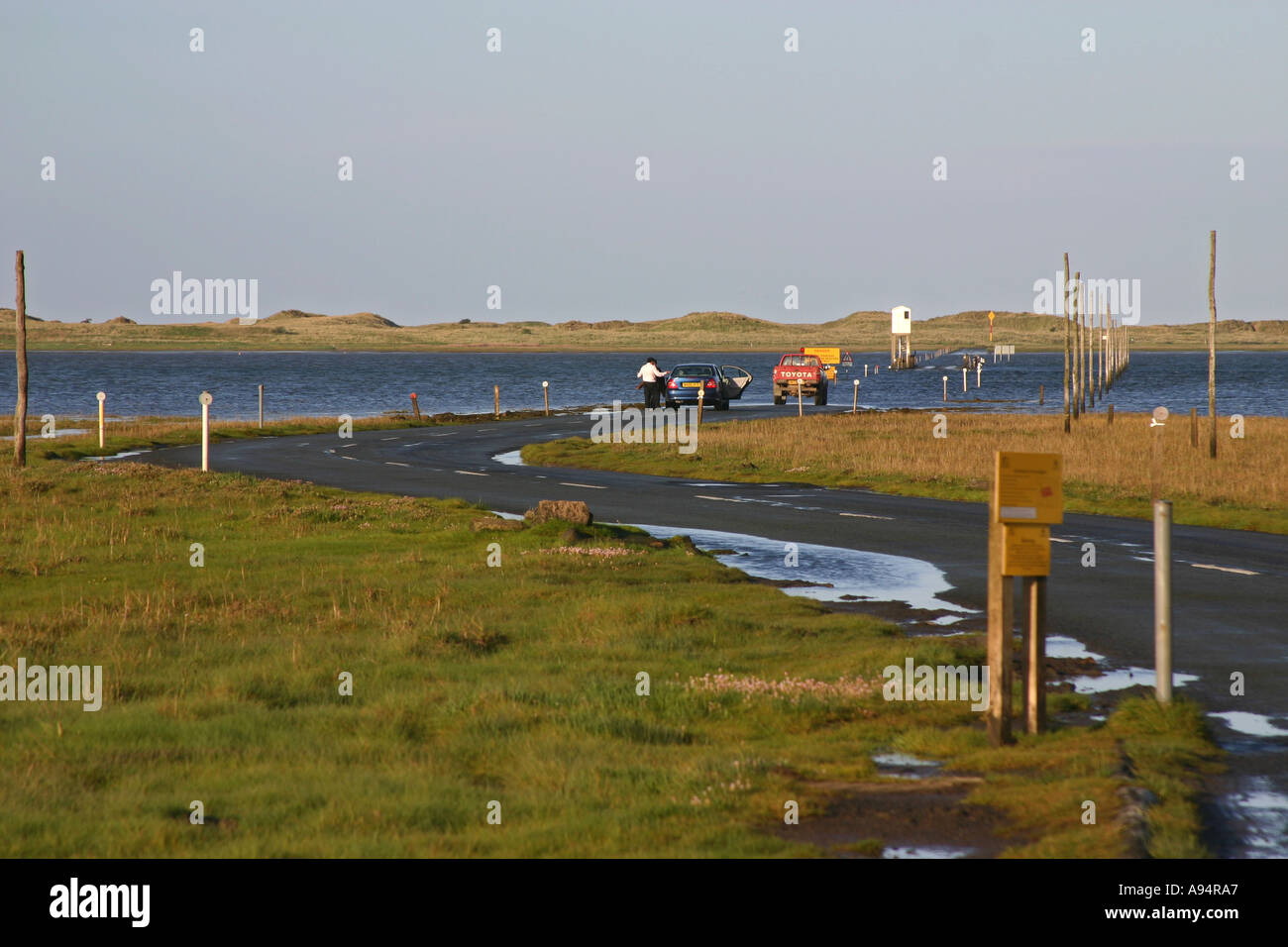 The causeway from the mainland to Lindisfarne holy Island at high tide from the mainland side Stock Photo