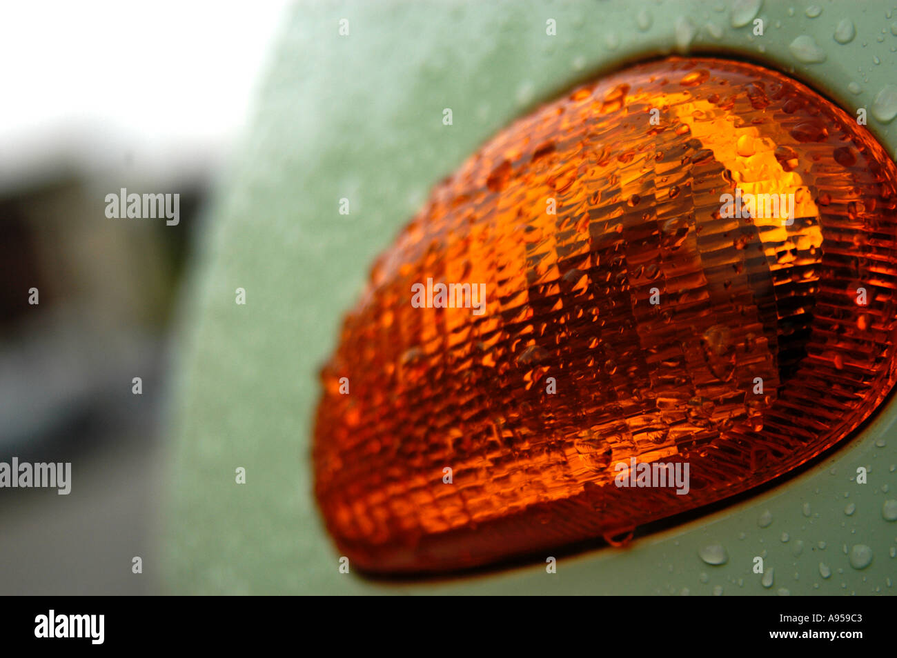 Detail of indicator light cluster on wet Vespa moped scooter, made by Piaggio. Shot in the pouring rain. Stock Photo