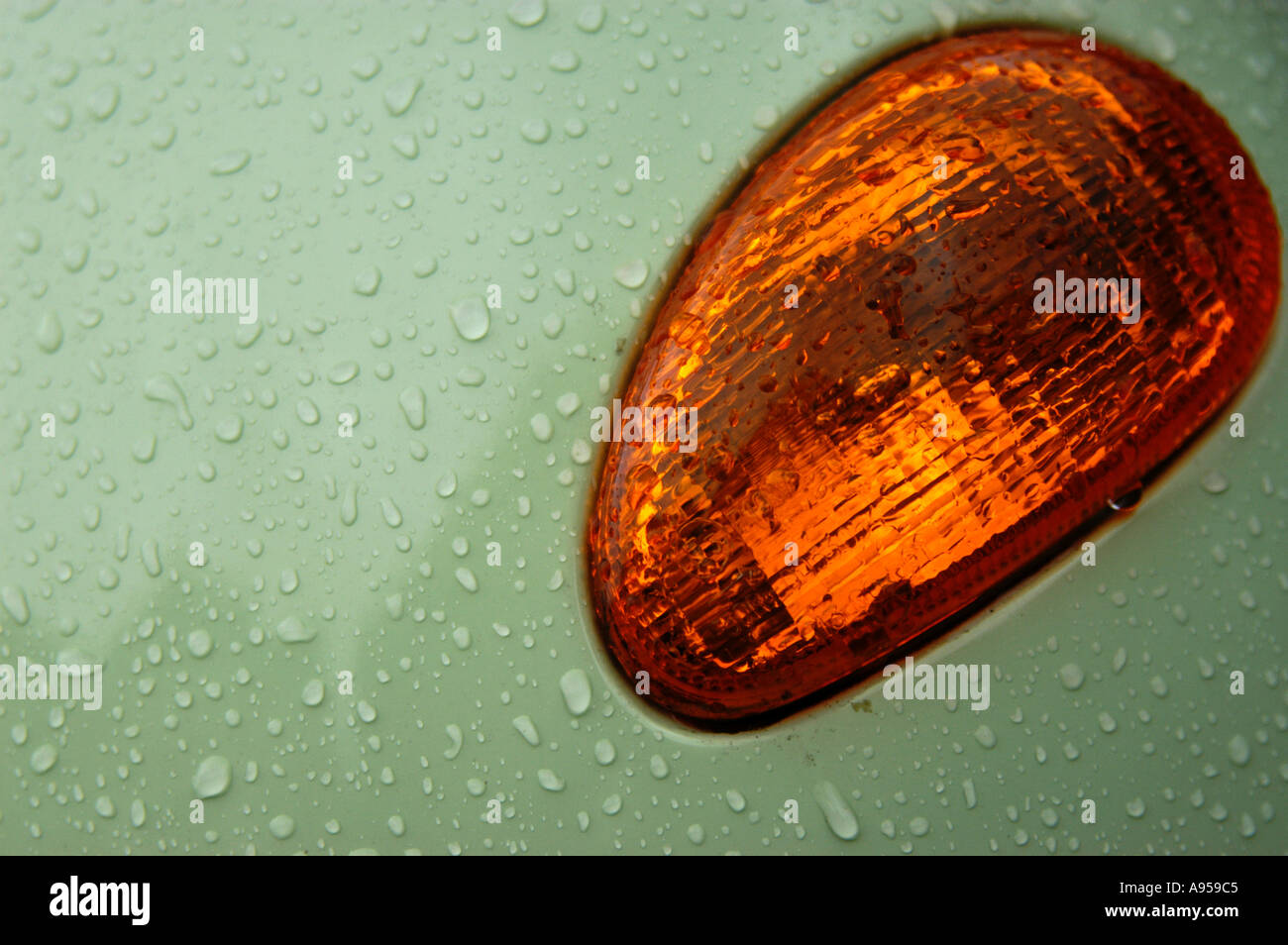 Detail of indicator light cluster on wet Vespa moped scooter, made by Piaggio. Shot in the pouring rain. Stock Photo