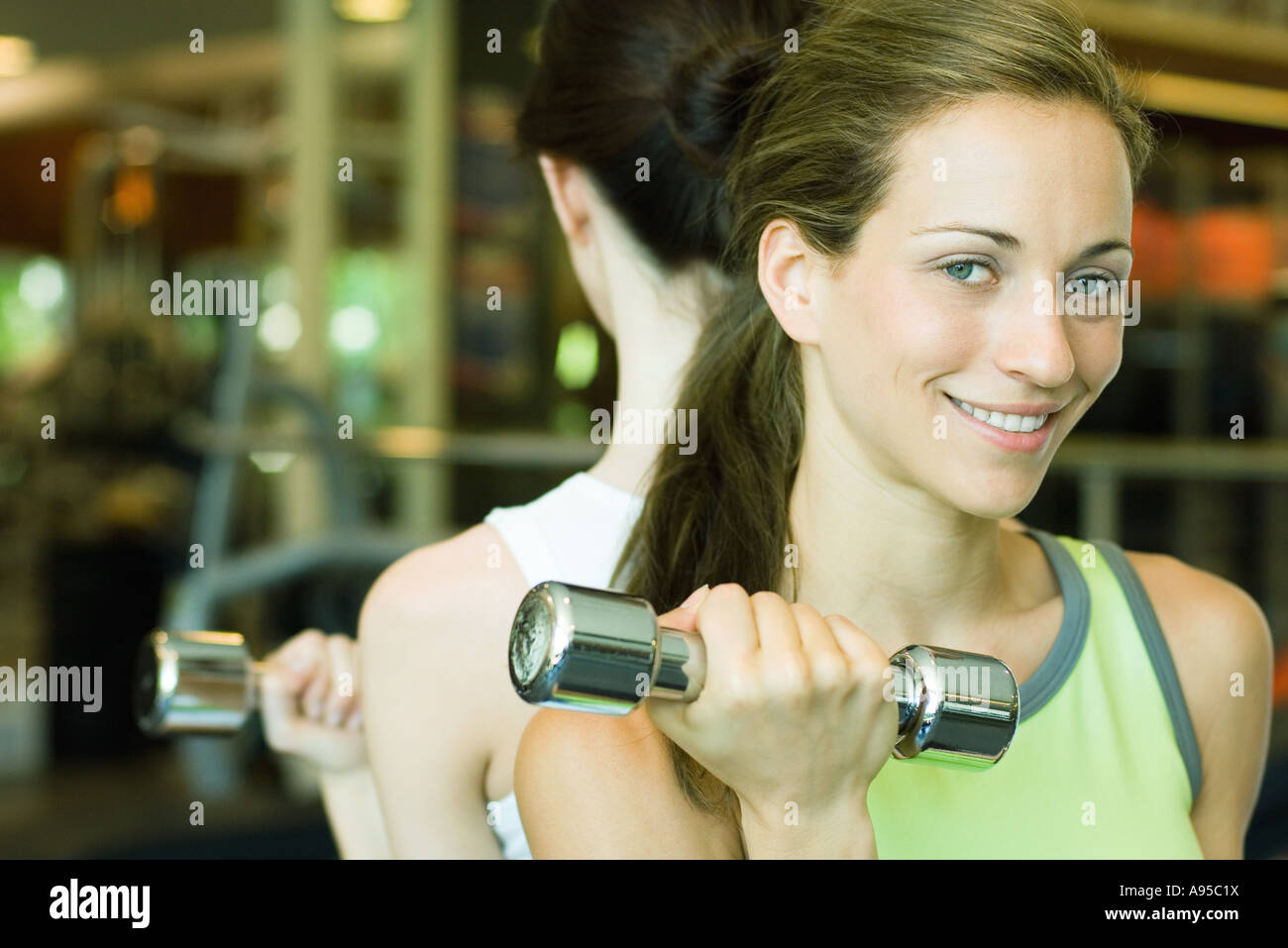 Two women lifting dumbbells, back to back Stock Photo Alamy
