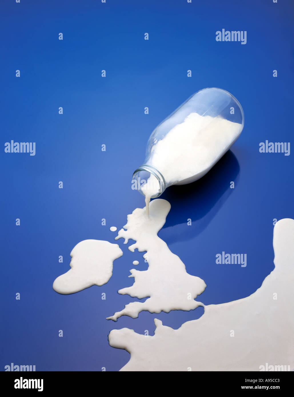 Milk spilling from bottle into shape of UK and Ireland map Stock Photo