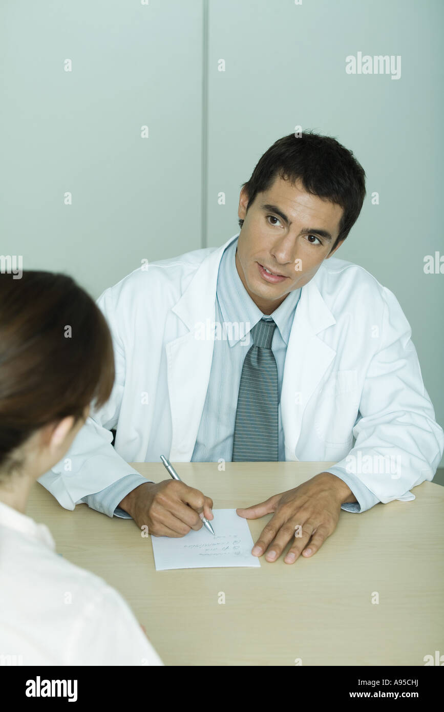 Doctor sitting across from patient, taking notes Stock Photo