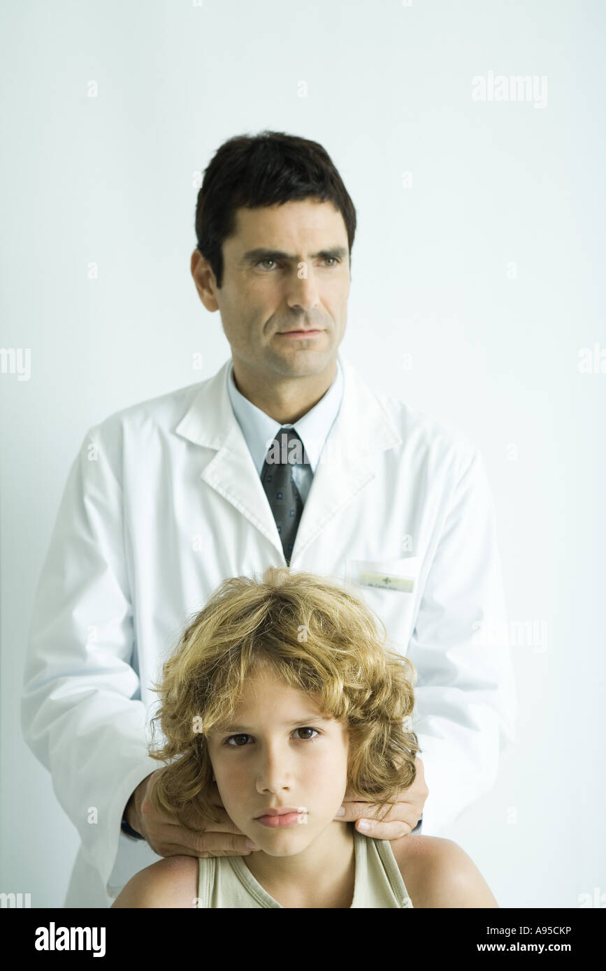 Doctor feeling boy's neck Stock Photo