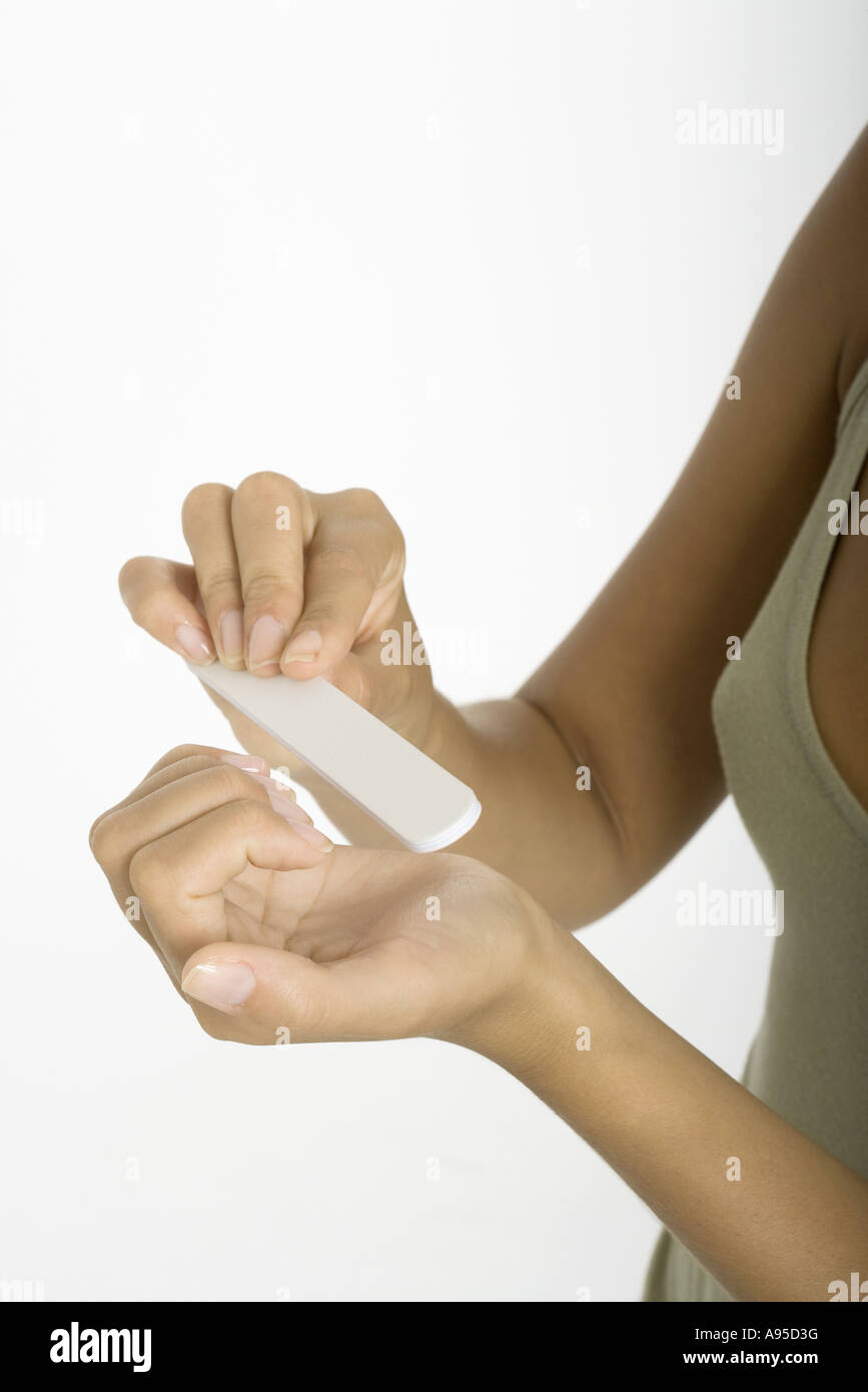 Young woman filing nails, close-up of hands Stock Photo