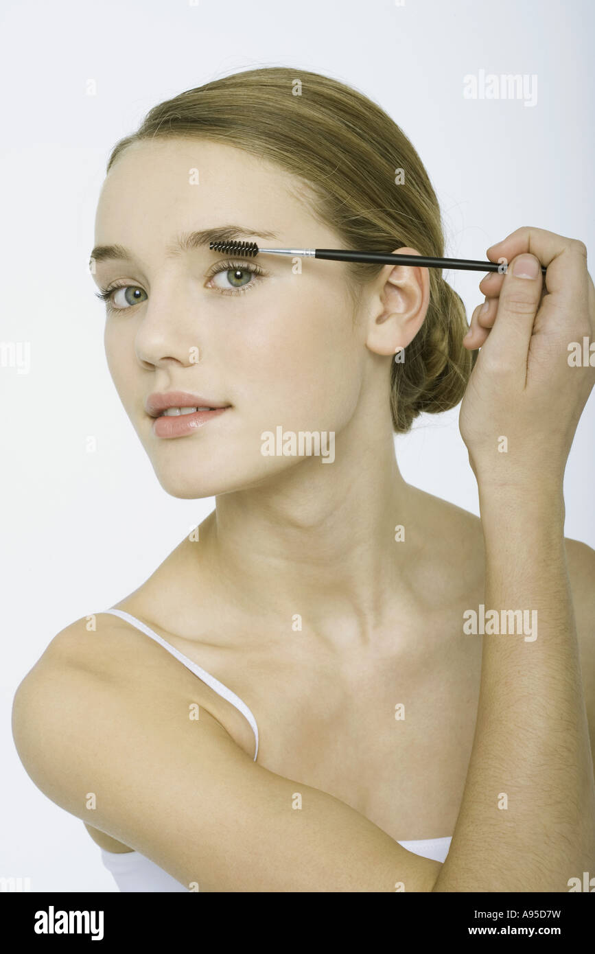 Teenage girl applying eye make-up Stock Photo