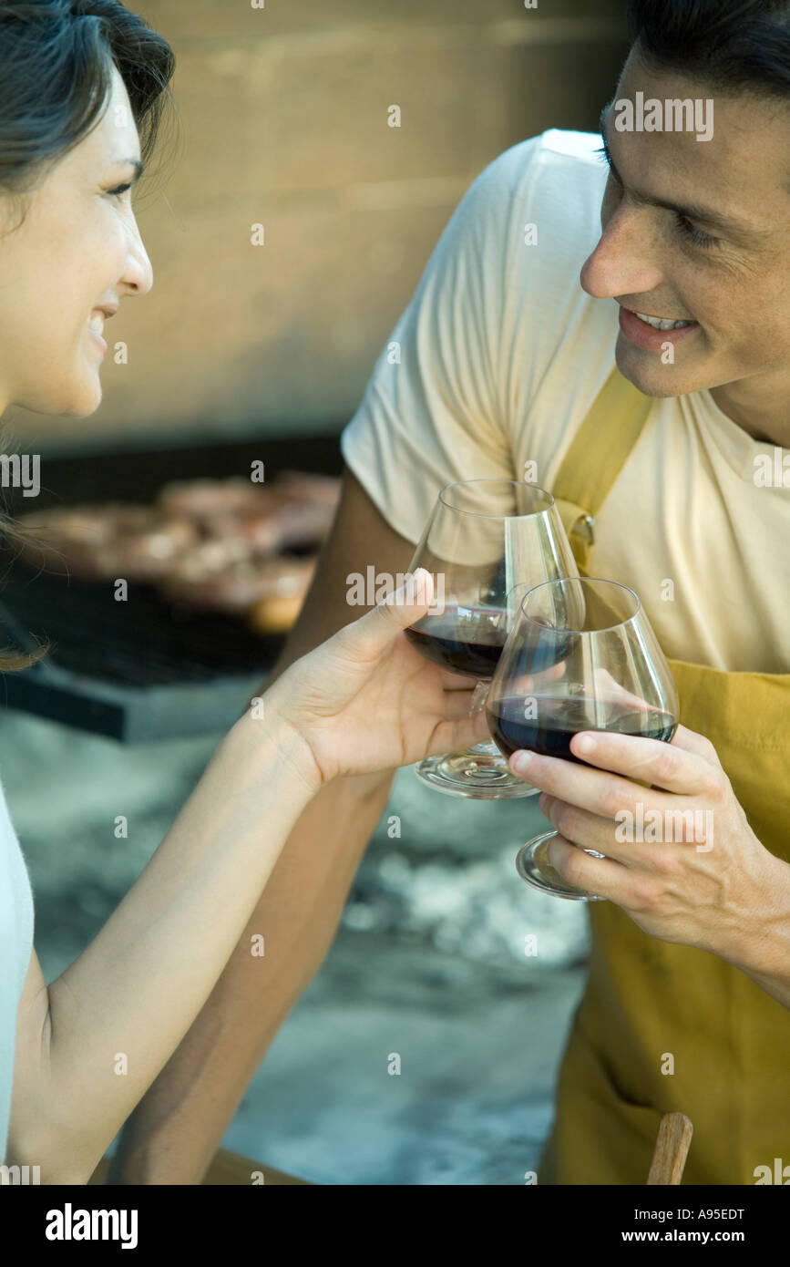 Couple having cookout and clinking wine glasses Stock Photo - Alamy