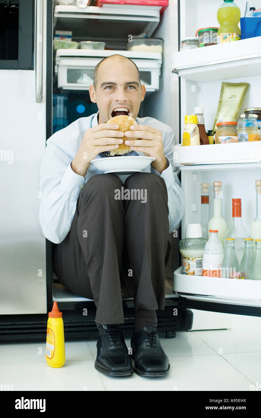 Man sitting inside refrigerator, eating sandwich Stock Photo - Alamy