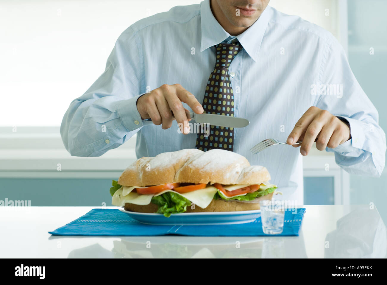 Man eating large sandwich with knife and fork Stock Photo Alamy