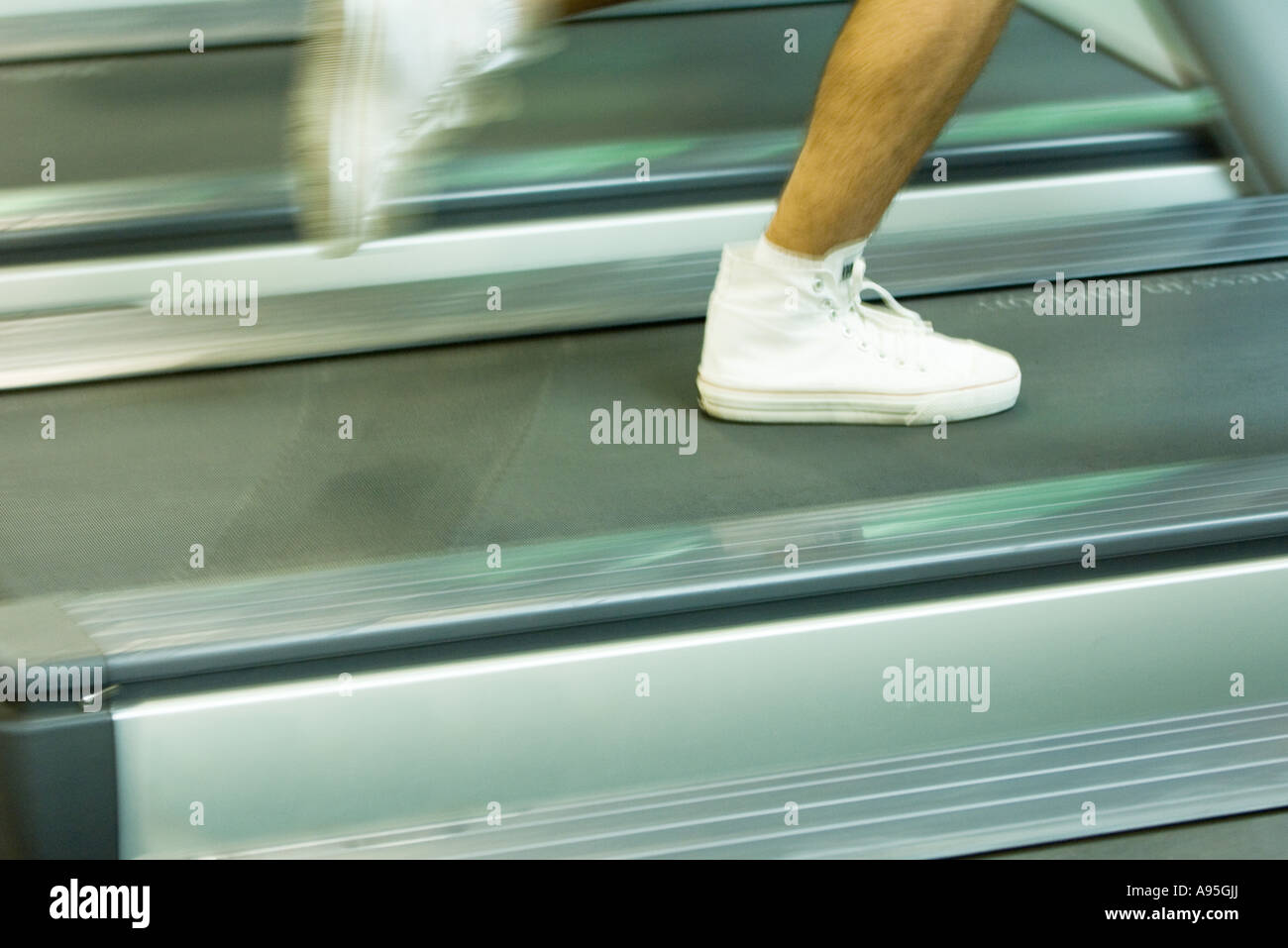 Man running on treadmill, close-up of feet Stock Photo