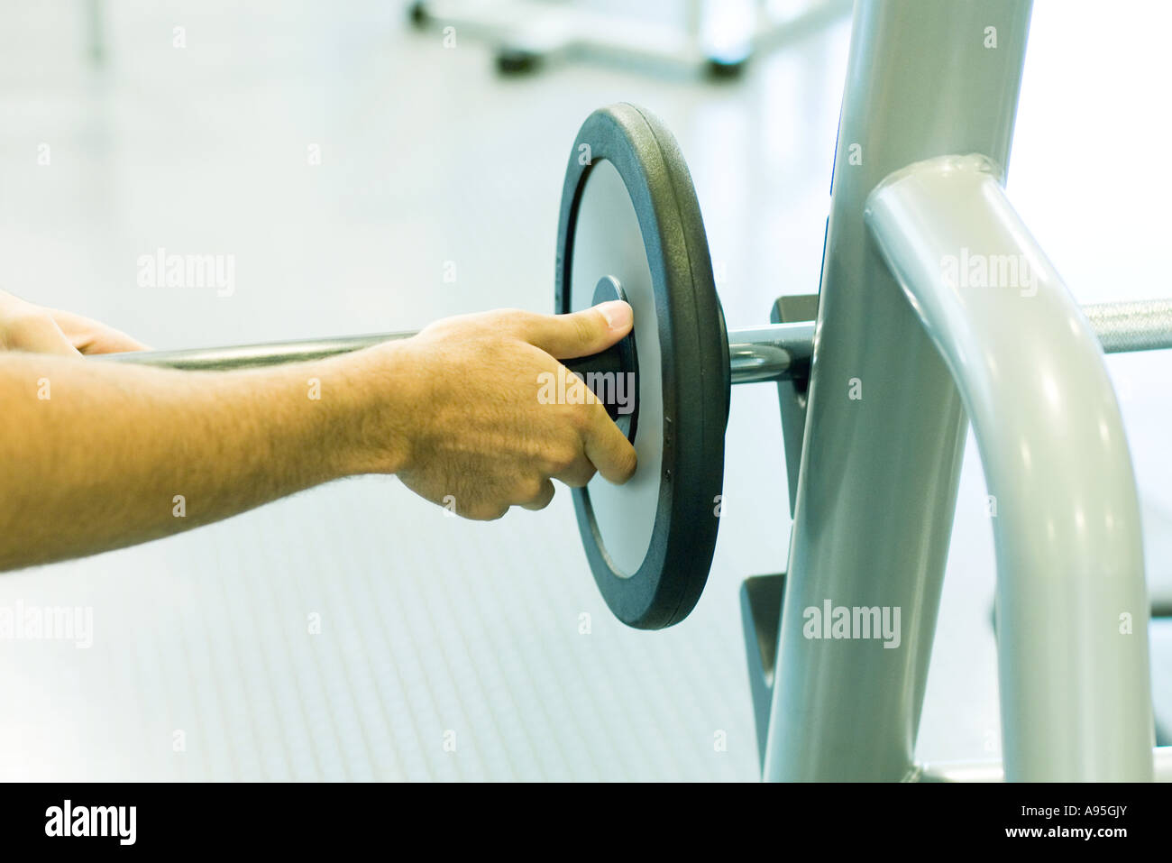 Man adjusting weight on barbell Stock Photo