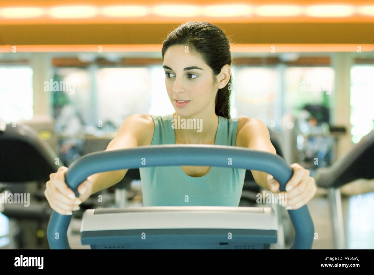 Woman using exercise machine Stock Photo