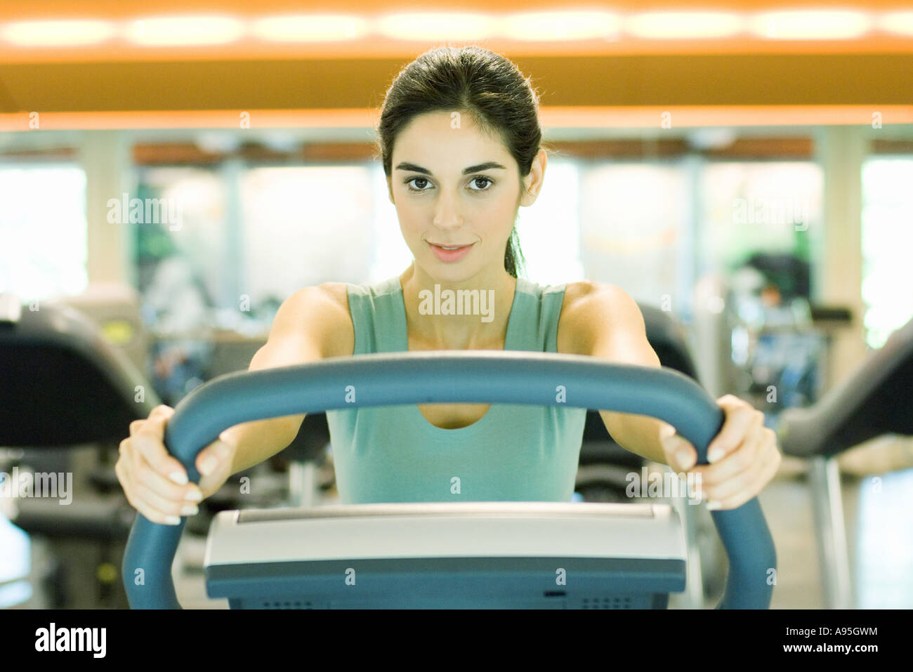 Woman using exercise machine Stock Photo