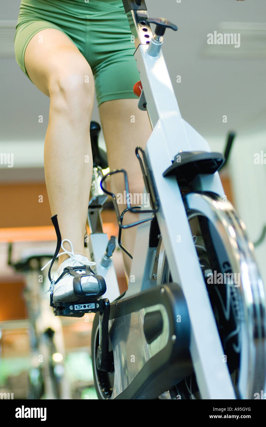 Woman riding exercise bike, waist down Stock Photo