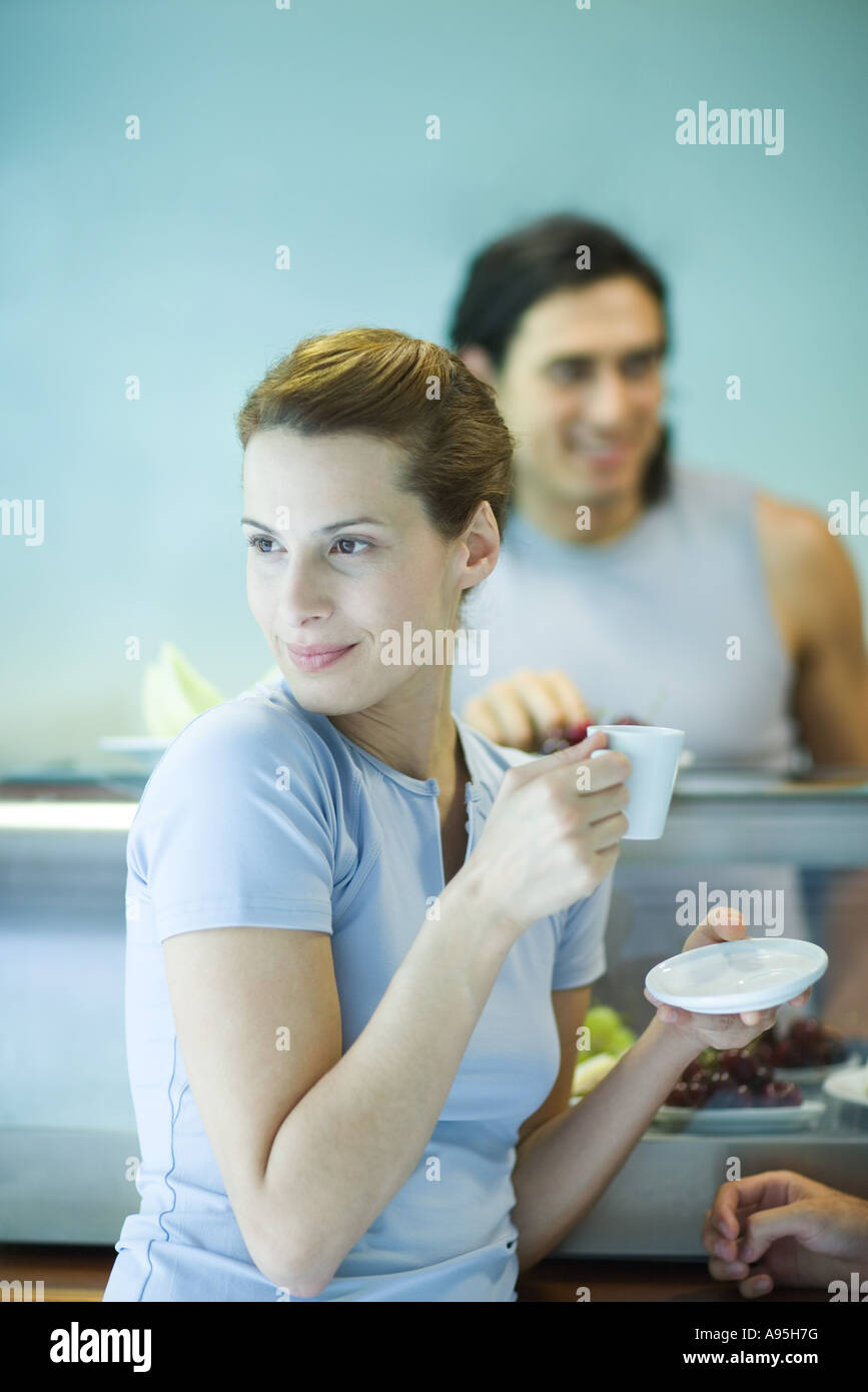 Young woman drinking coffee at snack bar, looking away Stock Photo Alamy